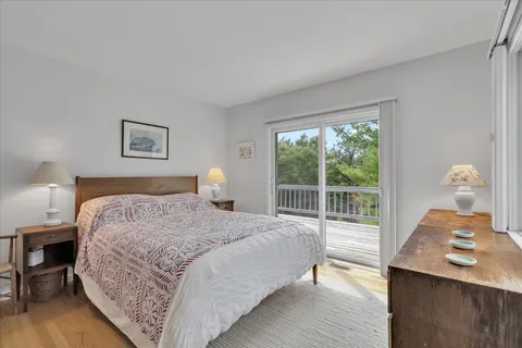 a bedroom with a bed and a lamp on dresser