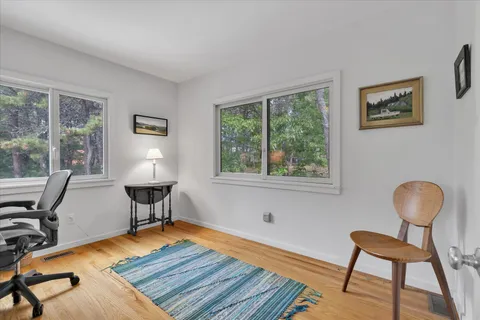 a view of a workspace with furniture and a window