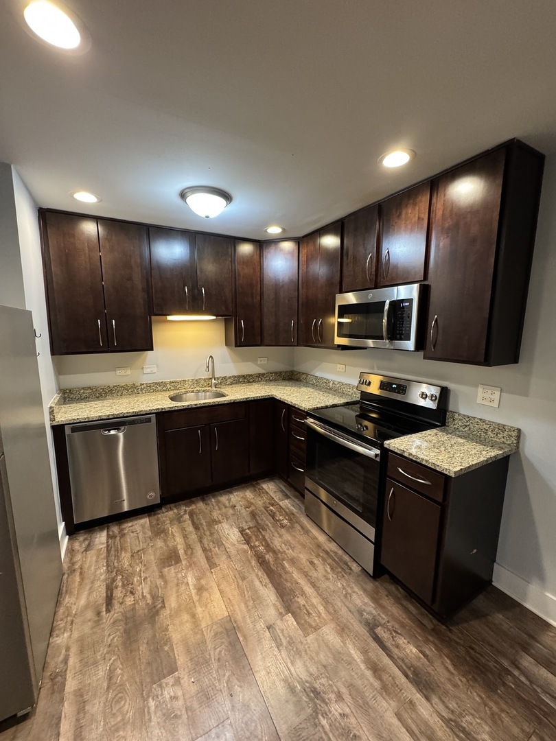 1443 Homestead Road, Unit 2NW La Grange Park, IL 60526 - Photo 6 of 13 a large kitchen with a large counter top stainless steel appliances and cabinets