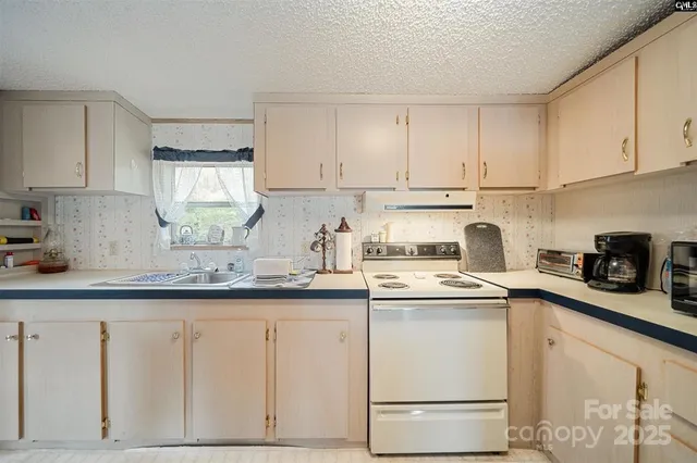a kitchen with granite countertop white cabinets white appliances and sink