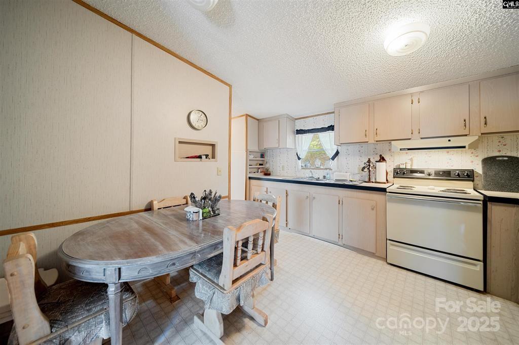 2342 Beaver Creek Road Camden, SC 29020 - Photo 13 of 26 a kitchen with a table chairs sink and cabinets