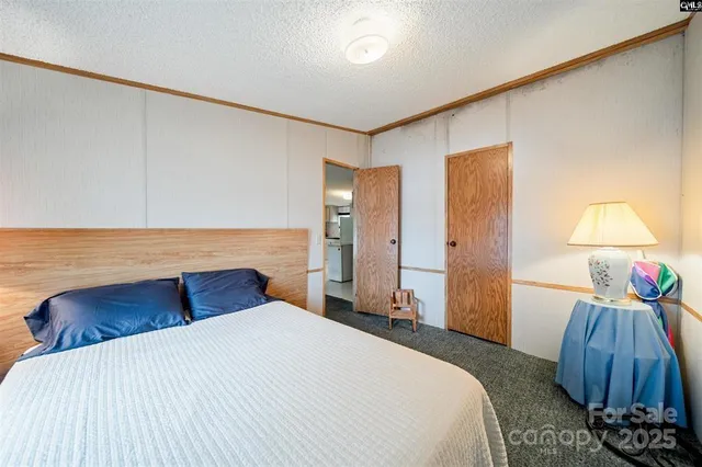 a bedroom with a bed and a lamp on the dresser