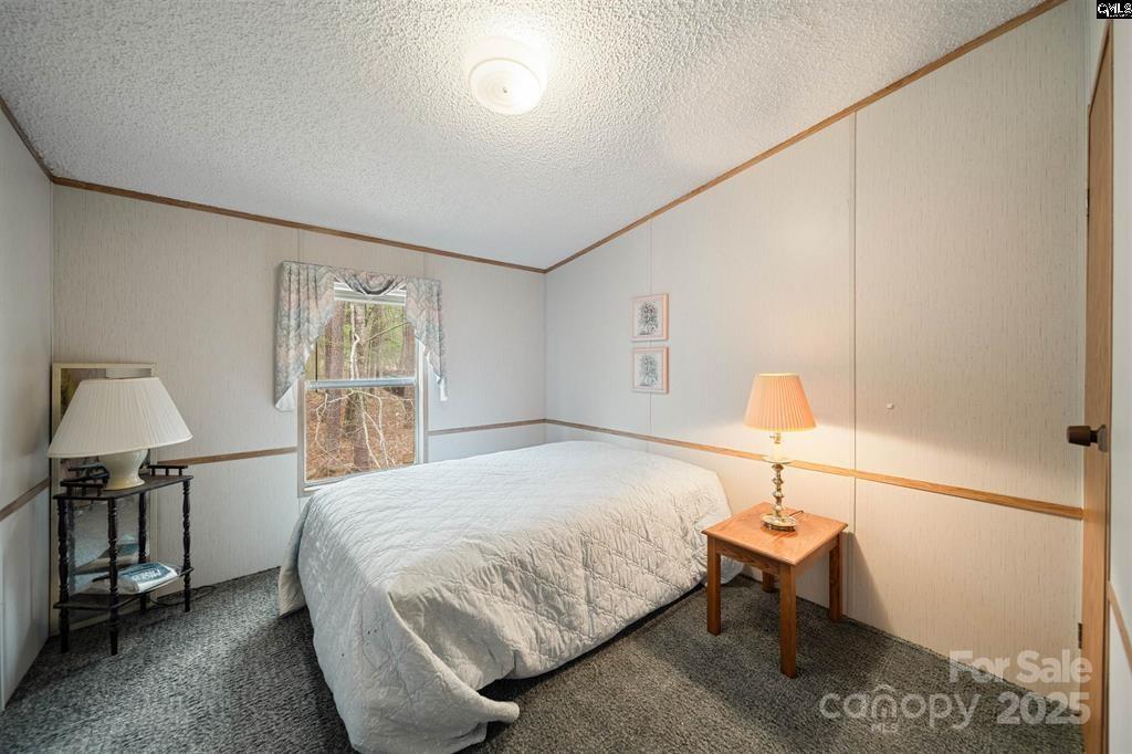 2342 Beaver Creek Road Camden, SC 29020 - Photo 21 of 26 a bedroom with a bed and a lamp on table