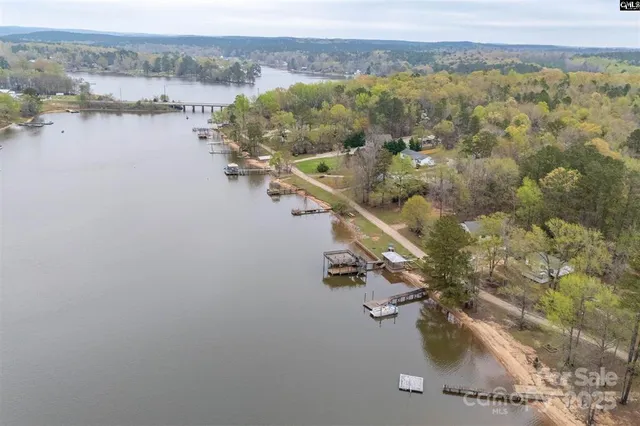 an aerial view of lake residential house with outdoor space and mountain view
