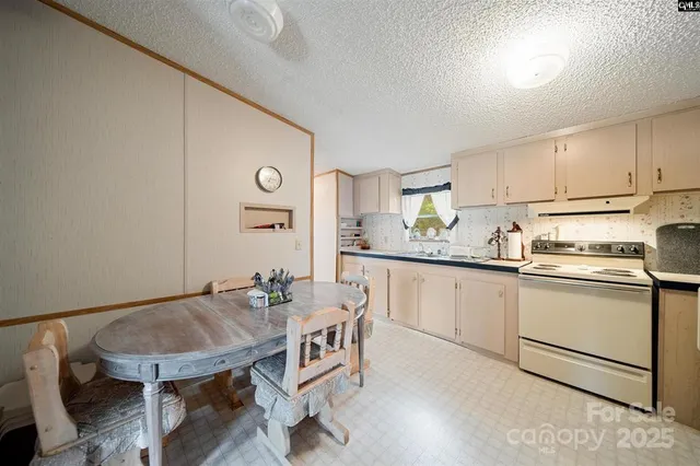 a kitchen with a dining table chairs and white cabinets