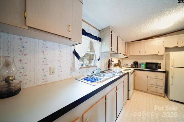 a kitchen with stainless steel appliances a sink a stove a refrigerator and cabinets