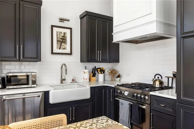 a kitchen with stainless steel appliances granite countertop a sink stove and cabinets