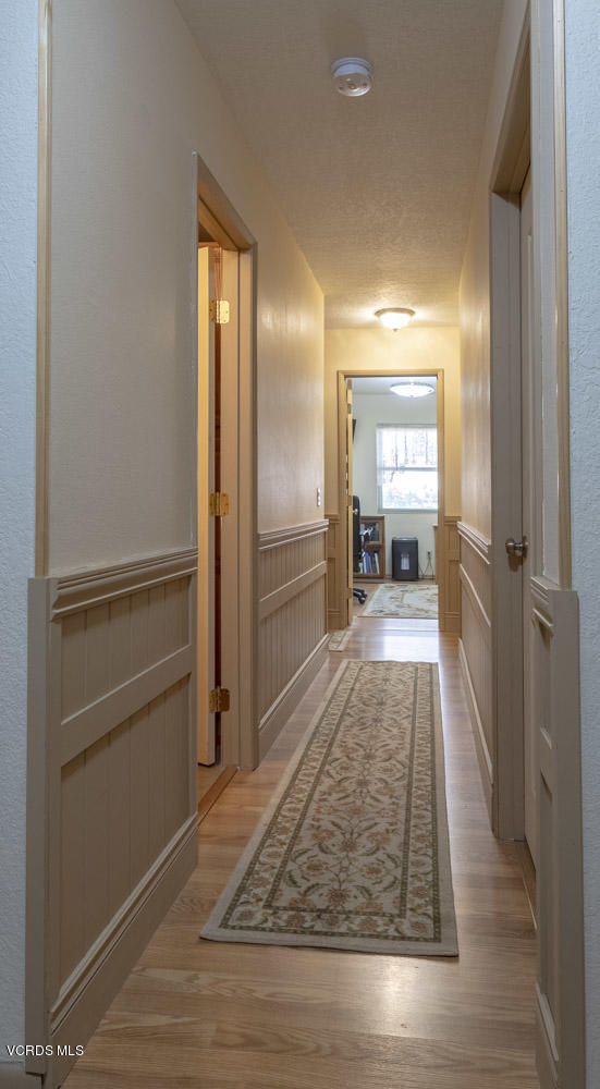 1642 Rambling Road Simi Valley, CA 93065 - Photo 14 of 39 a view of a hallway with wooden floor and a living room