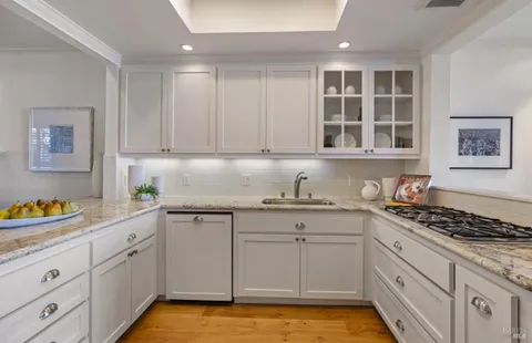 a kitchen with stainless steel appliances granite countertop a sink stove and cabinets