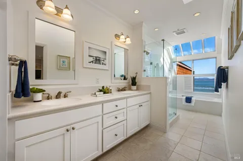 a spacious bathroom with a double vanity sink a mirror and a bathtub