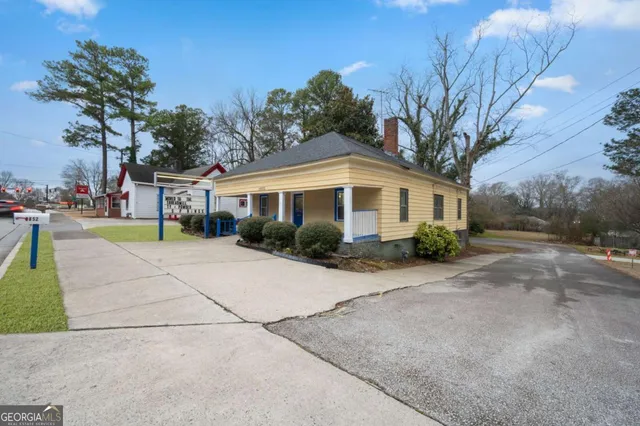 a front view of a house with a yard and potted plants