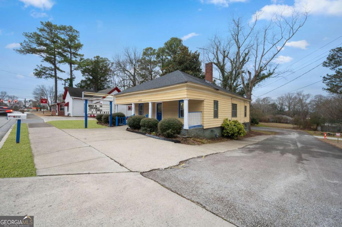 3852 New MacLand Road Powder Springs, GA 30127 - Photo 3 of 23 a front view of a house with a yard and potted plants