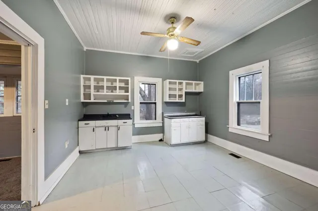 a large white kitchen with cabinets