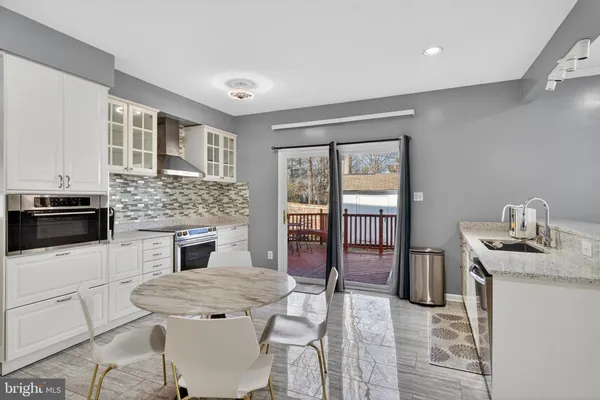 a kitchen with granite countertop a stove top oven a sink dishwasher and a refrigerator