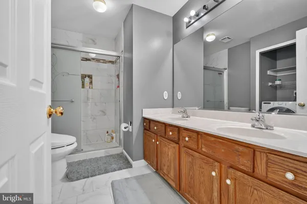 a spacious bathroom with double vanity sink a mirror and a shower