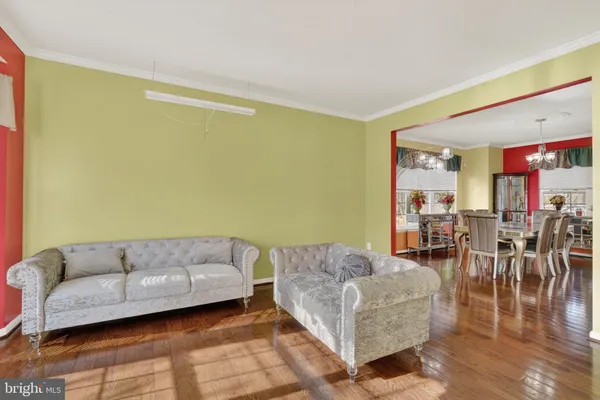 a living room with couches and a dining table with kitchen view