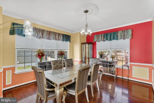 a view of a dining room and livingroom with furniture wooden floor a chandelier