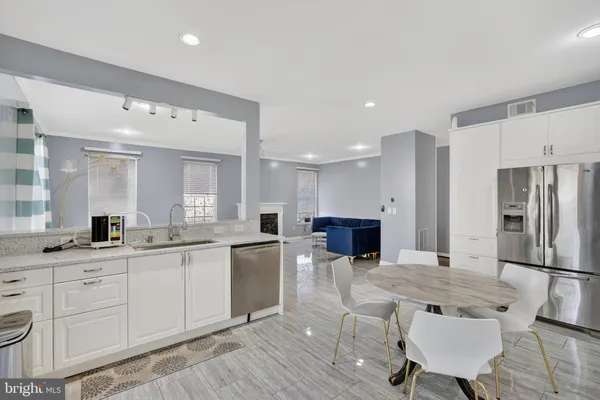 a kitchen with stainless steel appliances granite countertop a sink refrigerator and cabinets