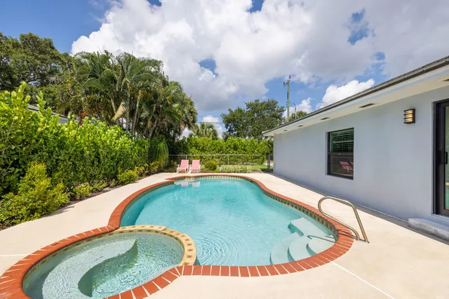 a view of a swimming pool with a yard from inside of the house