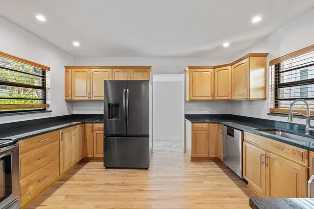 a kitchen with granite countertop wooden floors and stainless steel appliances