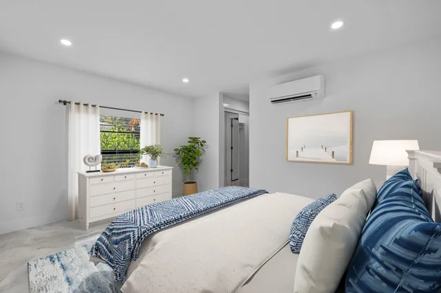 a bedroom with a bed and a large window