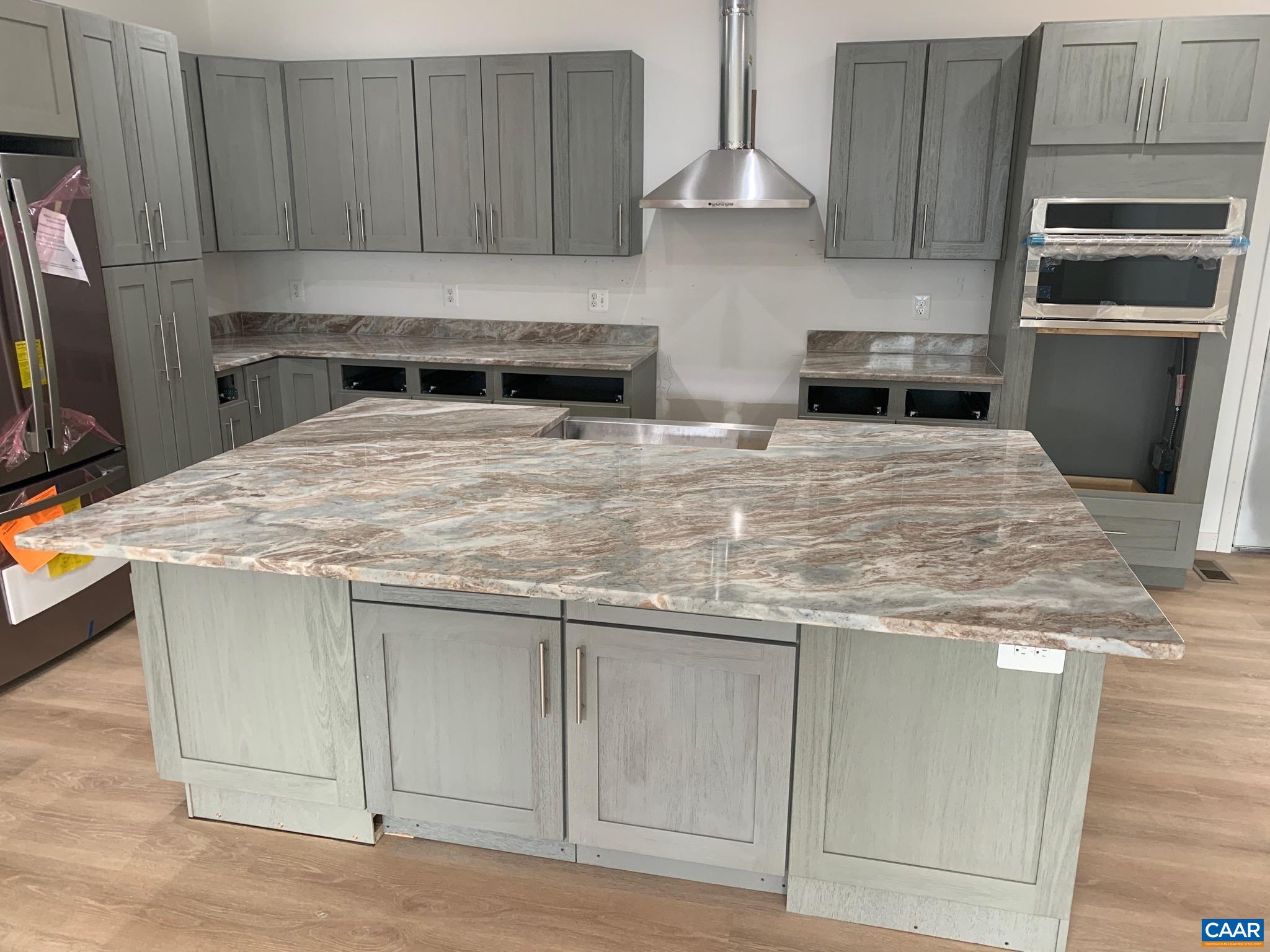 a kitchen with stainless steel appliances granite countertop a stove a sink and a refrigerator