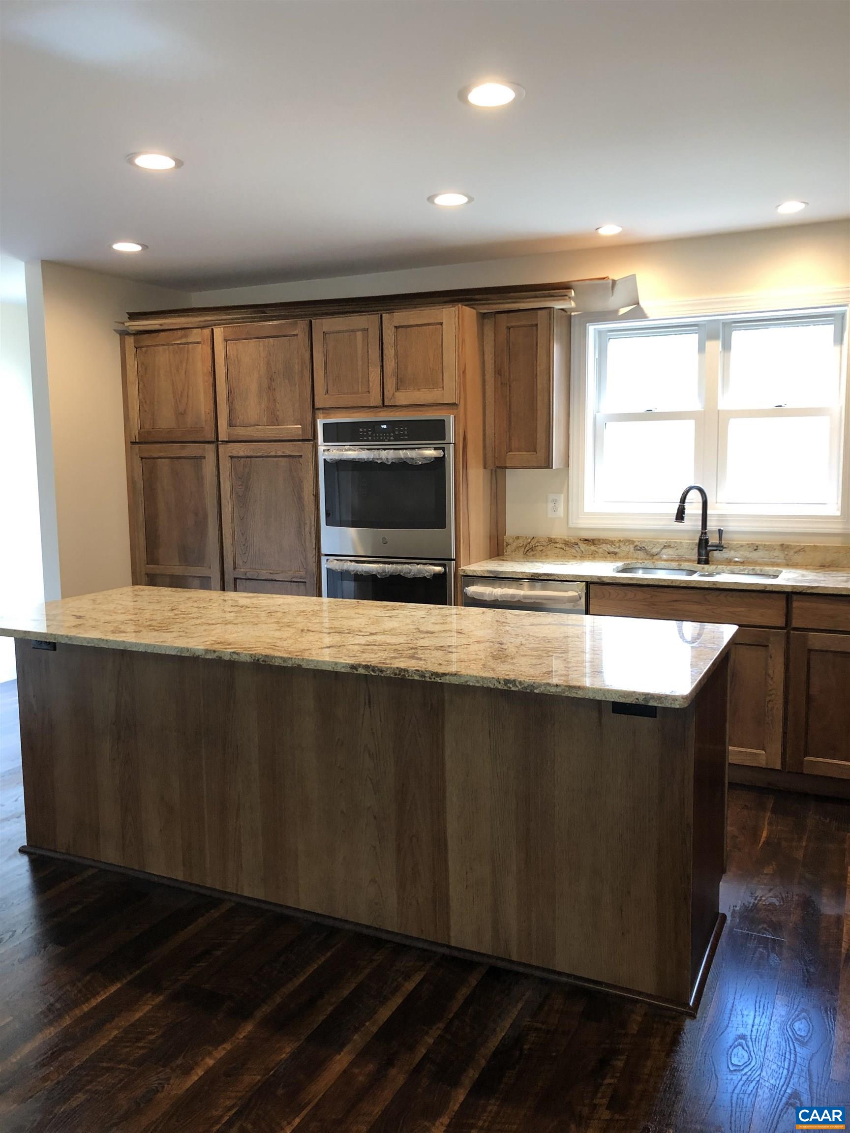 2150 C Moore Road, Unit LOT 7 Ruckersville, VA 22968 - Photo 5 of 7 a kitchen with stainless steel appliances granite countertop a stove a sink and a microwave
