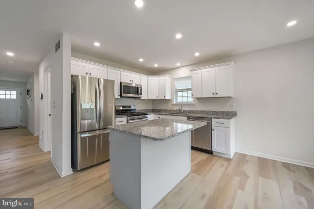 a kitchen with stainless steel appliances granite countertop a refrigerator and a sink