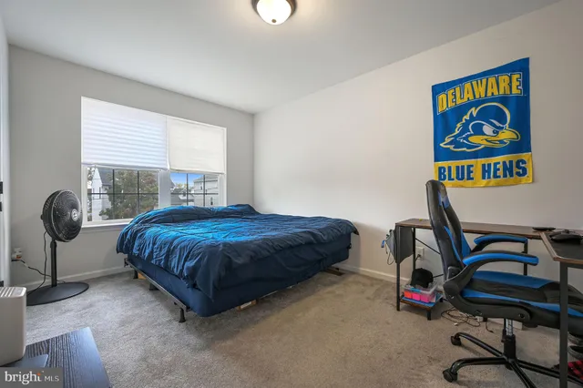 a bedroom with a bed and a desk in it