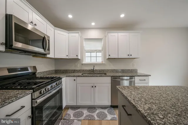 a kitchen with stainless steel appliances granite countertop a sink and a stove