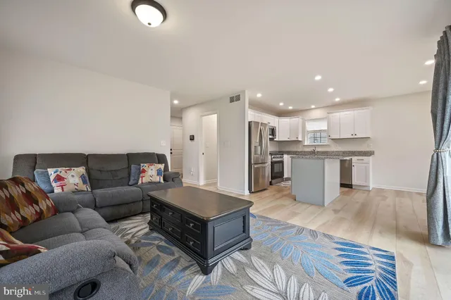 a living room with furniture and kitchen view