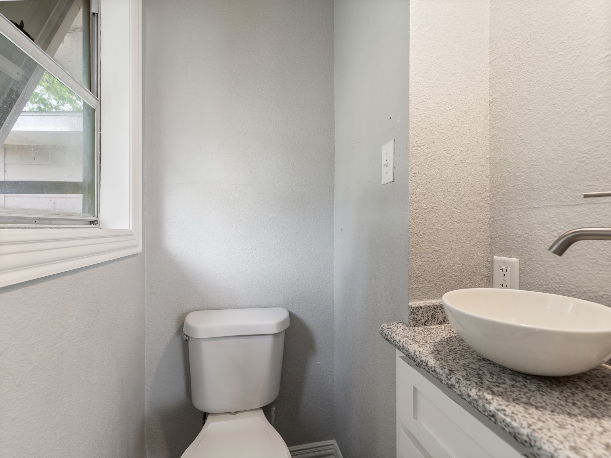1921 Foote Street Wharton, TX 77488 - Photo 13 of 18 a bathroom with a granite countertop toilet a sink and a mirror