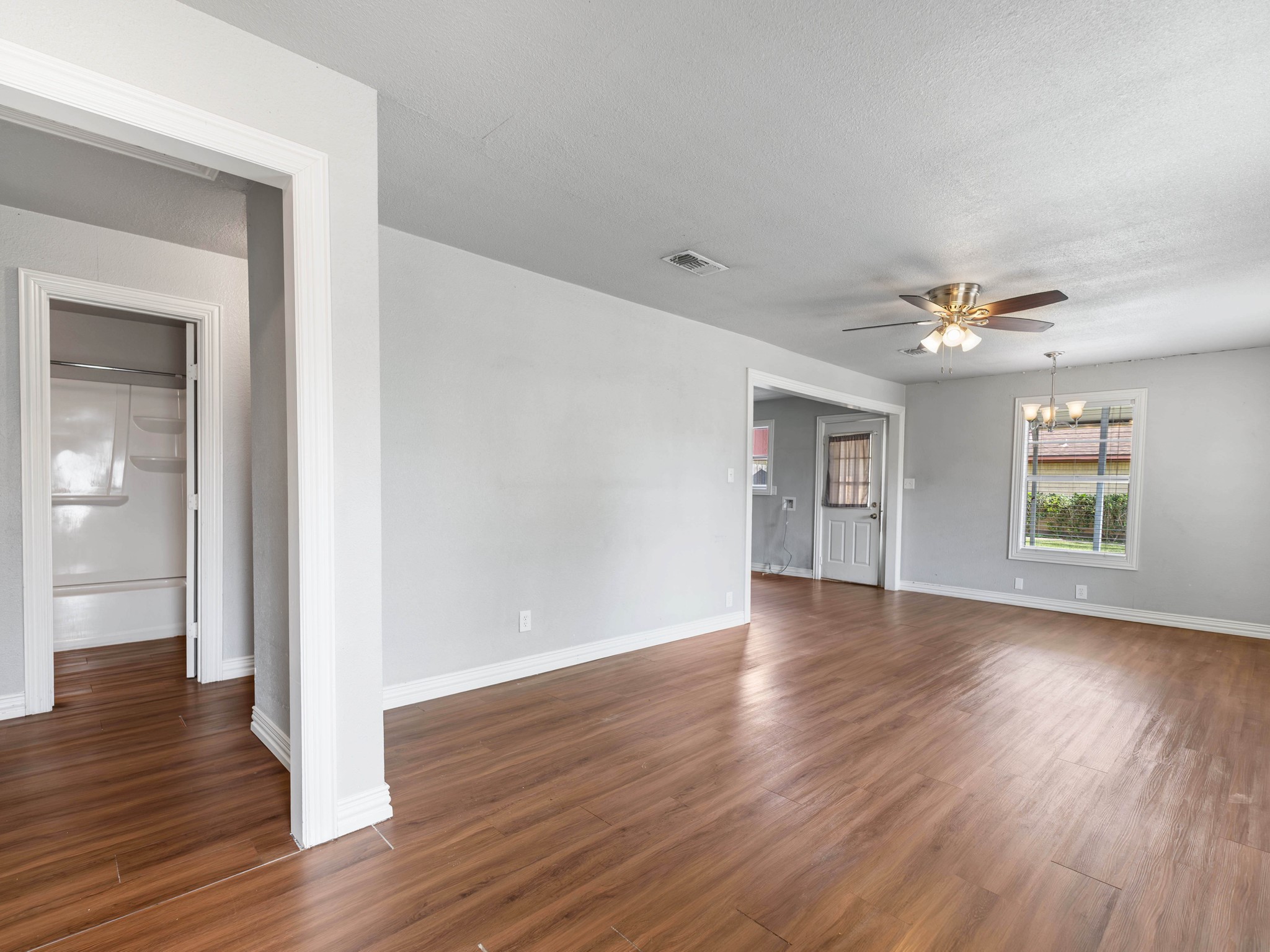 1921 Foote Street Wharton, TX 77488 - Photo 3 of 18 an empty room with wooden floor chandelier and windows