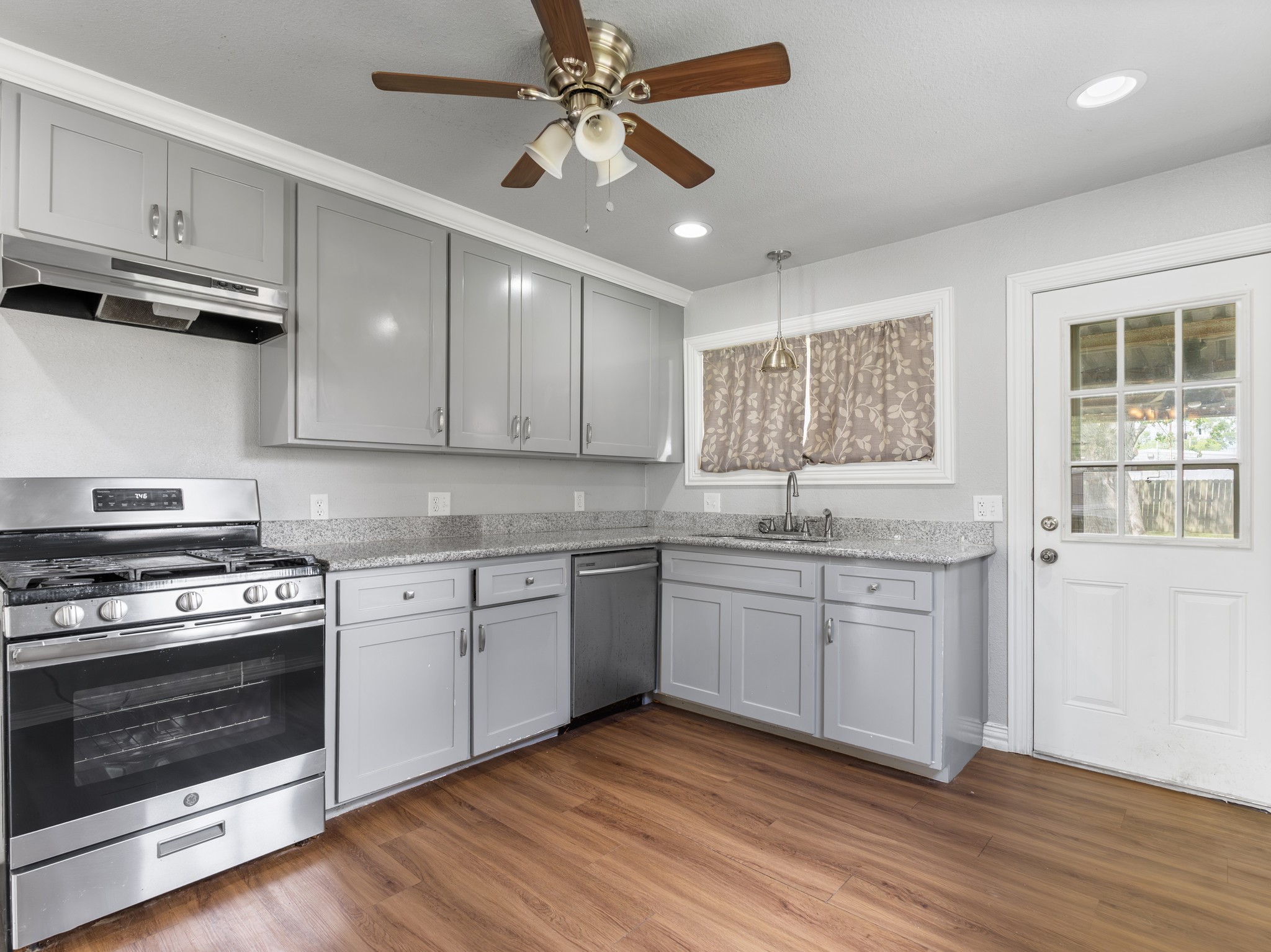 1921 Foote Street Wharton, TX 77488 - Photo 6 of 18 a kitchen with granite countertop cabinets stainless steel appliances and wooden floor