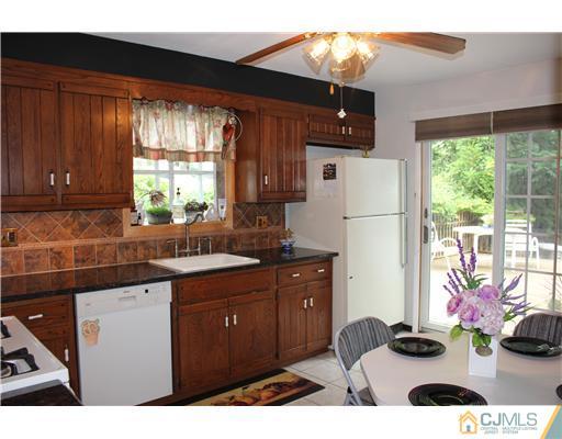 24 Old Post Road Edison, NJ 08817 - Photo 4 of 22 a kitchen with stainless steel appliances kitchen island granite countertop a refrigerator a sink dishwasher with a dining table and chairs