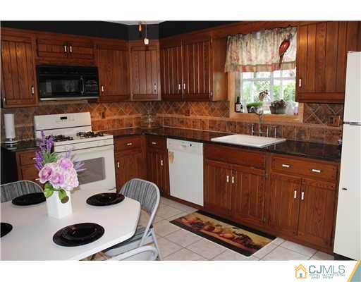 24 Old Post Road Edison, NJ 08817 - Photo 5 of 22 a kitchen with a cabinets a stove and a microwave
