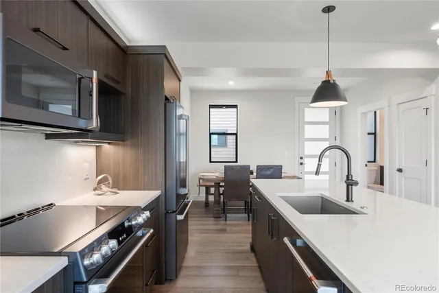 a kitchen with kitchen island a sink stove top oven and microwave