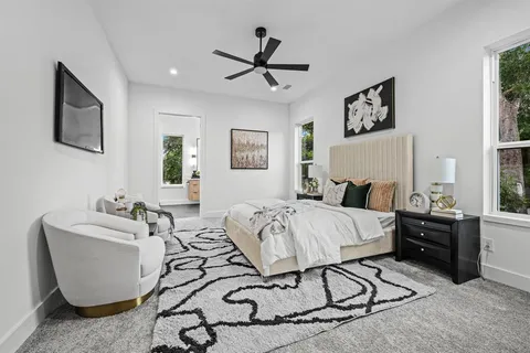 a spacious bedroom with a bed a couch and a window