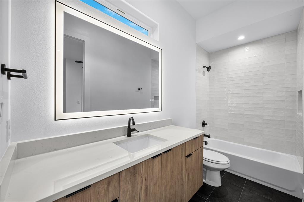 812 West 10th Street Dallas, TX 75208 - Photo 22 of 27 a bathroom with a granite countertop sink a toilet and a bathtub