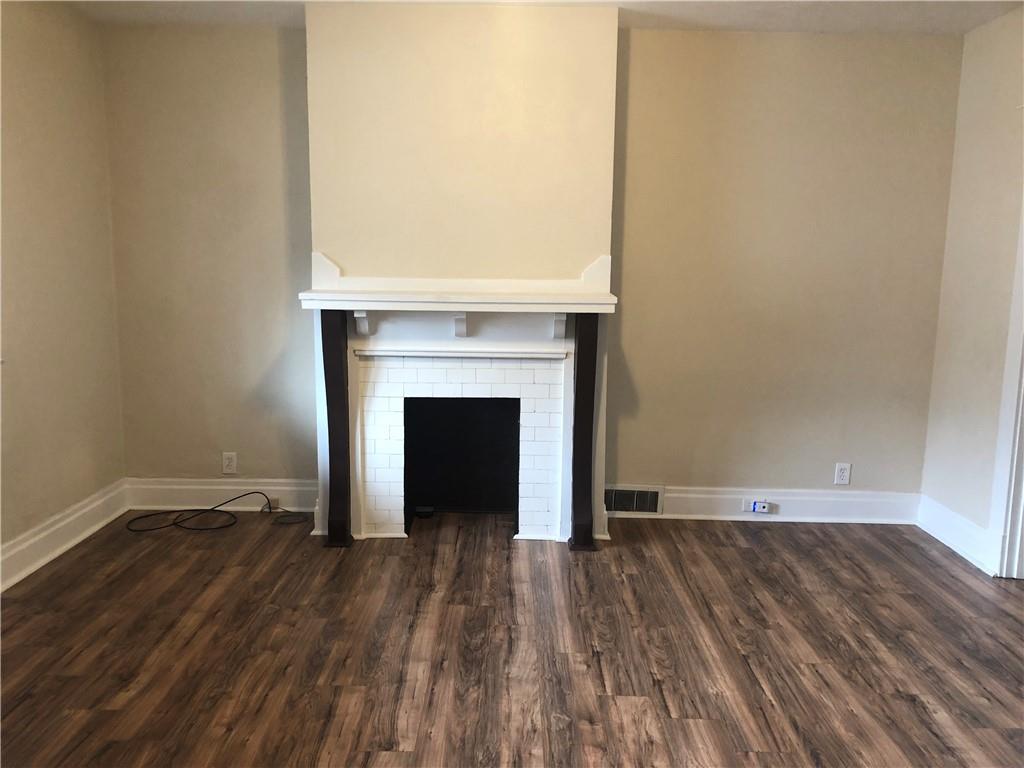 1141 9th Street McKees Rocks, PA 15136 - Photo 3 of 21 a view of an empty room with wooden floor and a fireplace