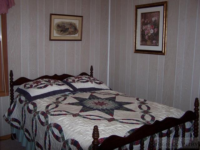 355 Trout Lake Road Deep Gap, NC 28618 - Photo 31 of 45 a bed sitting in a bedroom next to a wooden table