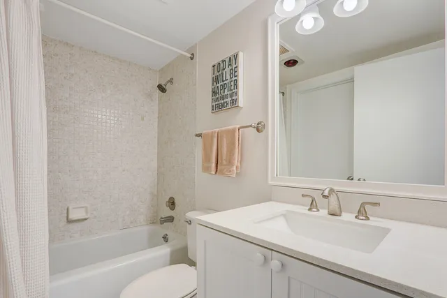 a bathroom with a sink vanity granite tub shower and a mirror