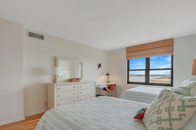 a bedroom with a bed and a large window