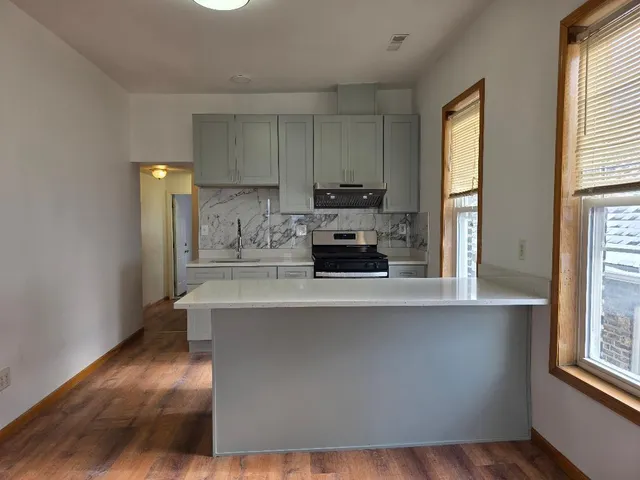 a kitchen with stainless steel appliances a sink a stove a refrigerator a window