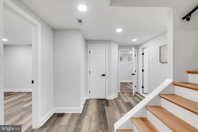 a view of a hallway with wooden floor and staircase