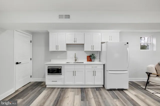 a kitchen with white cabinets and white appliances