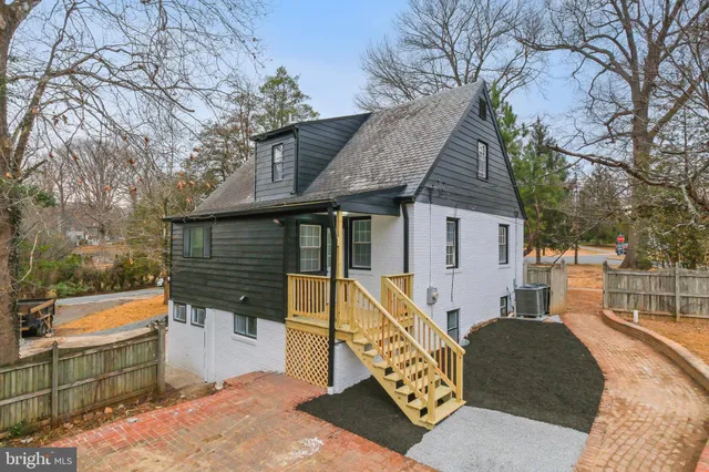 a view of a house with backyard and a trees