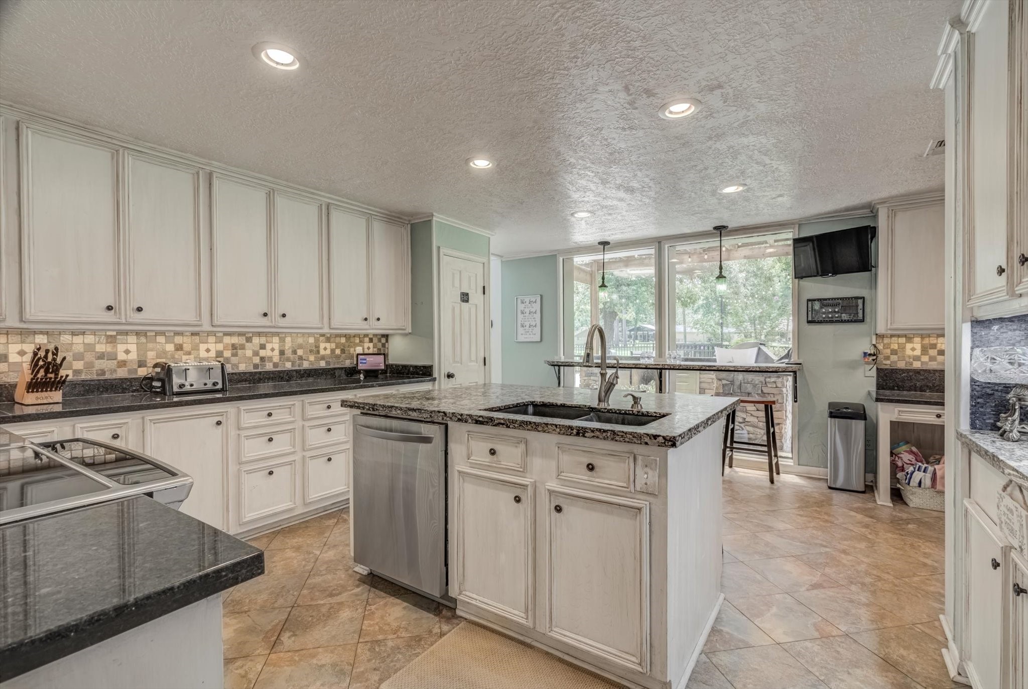 22 Winged Foot Drive Conroe, TX 77304 - Photo 16 of 49 a kitchen with stainless steel appliances granite countertop stove top oven a sink a dining table and chairs