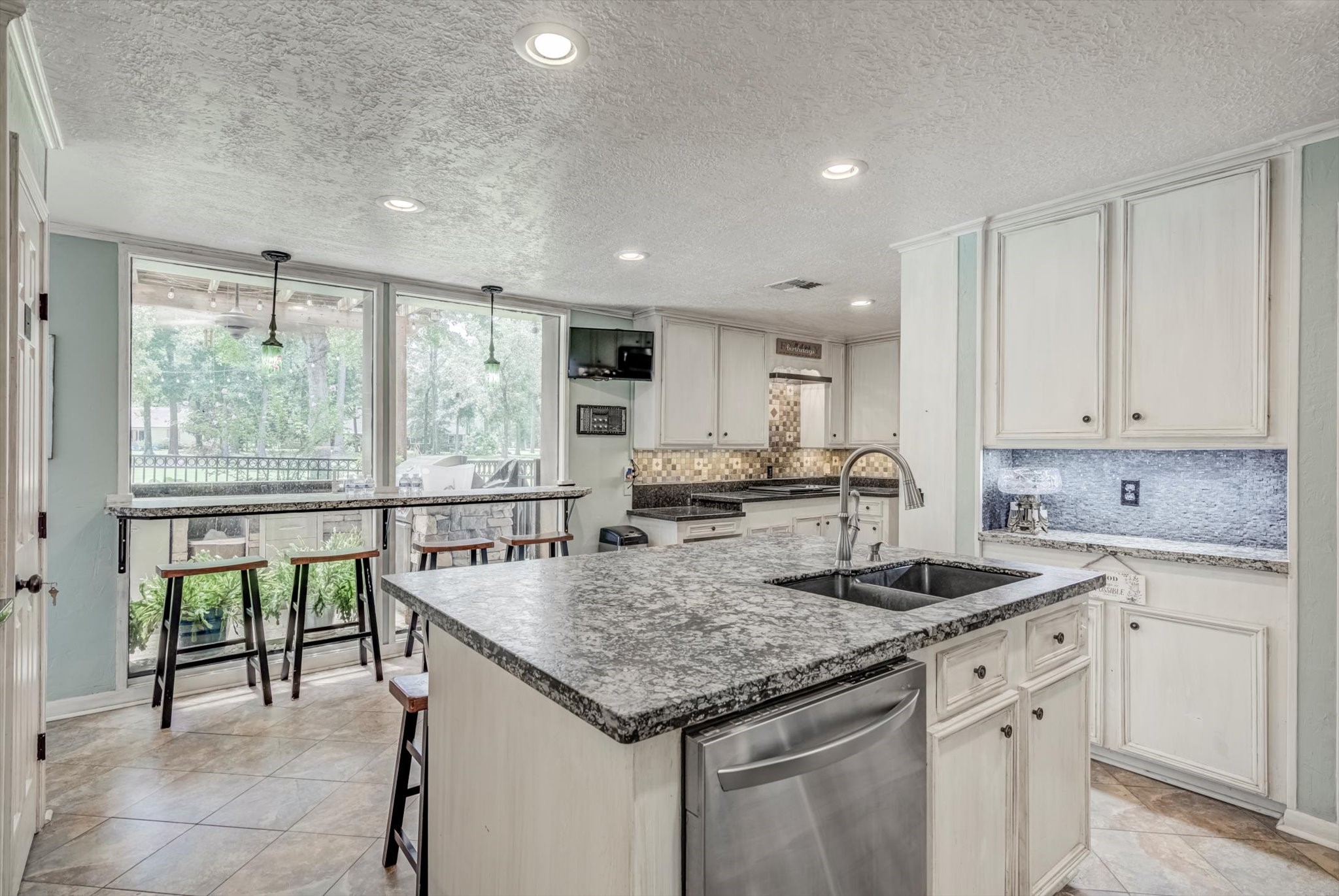 22 Winged Foot Drive Conroe, TX 77304 - Photo 19 of 49 a kitchen with granite countertop sink stove and white cabinets