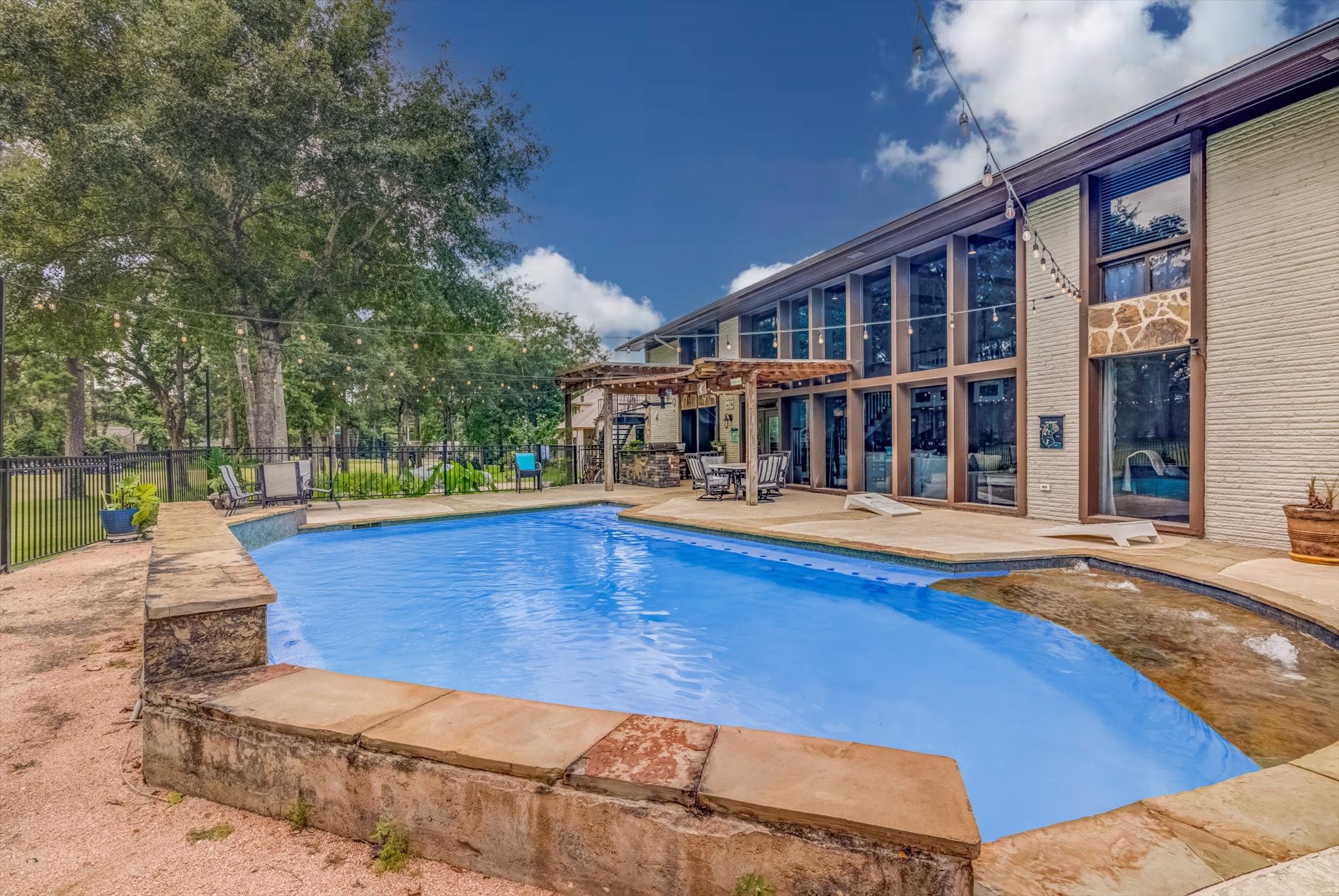 22 Winged Foot Drive Conroe, TX 77304 - Photo 42 of 49 a view of swimming pool with seating space and wooden fence